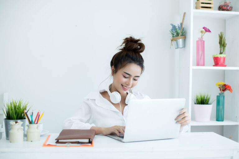 beautiful-young-woman-working-her-laptop-her-room-min